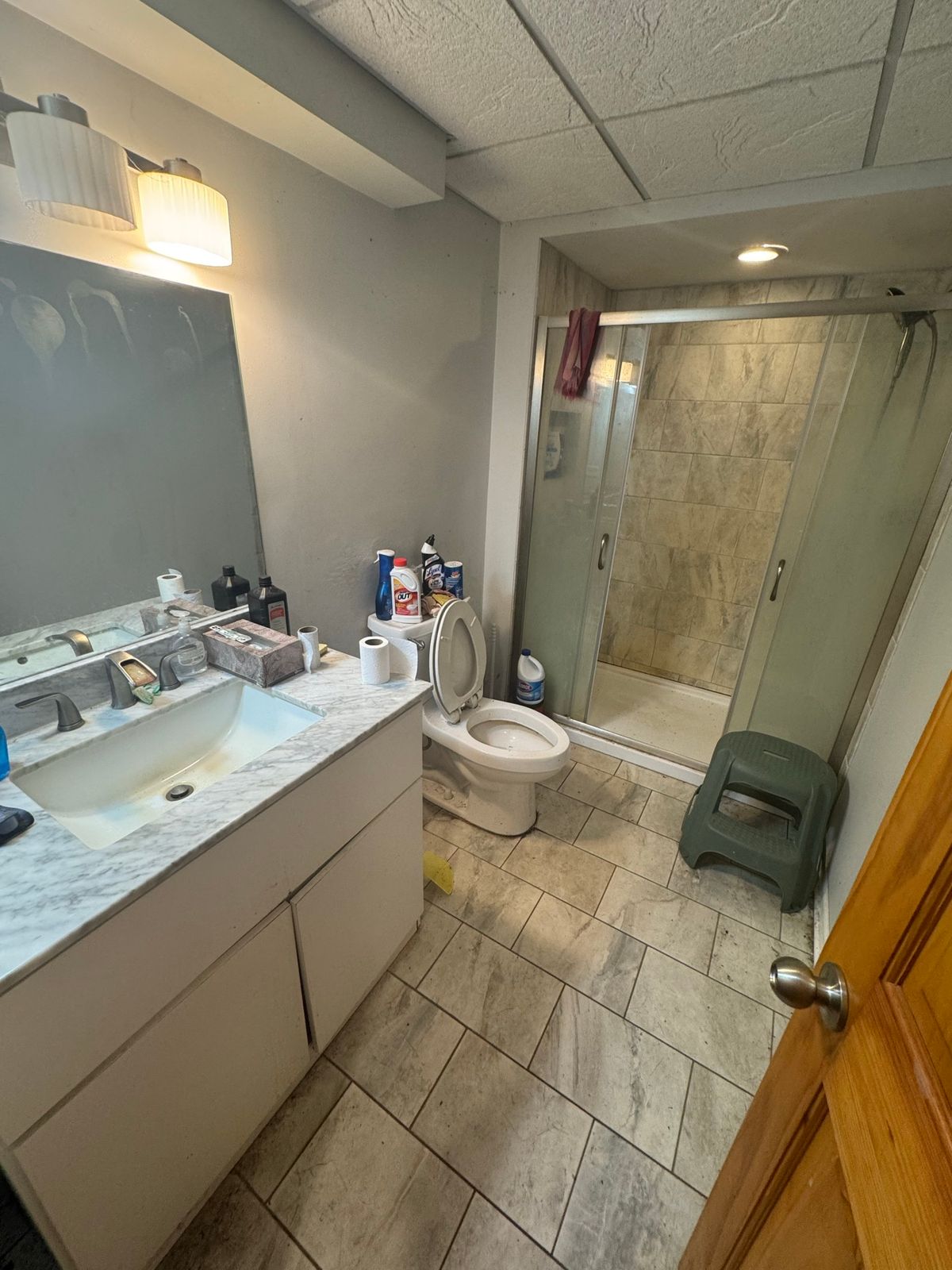 Bathroom before the remodel, with a white vanity and gray floor tile