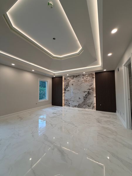 Corner view of the bedroom with the lit tray ceiling and the accent wall