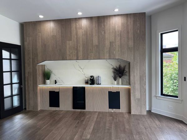 Coffee-bar niche in a wood-look wall, with a slat-panel base cabinet and a marble-look back panel