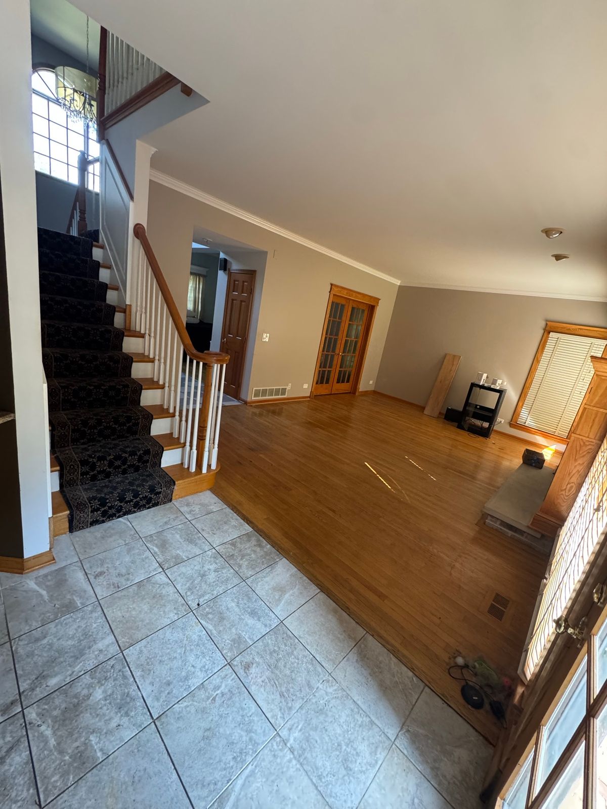 Entry and stairs before, with carpeted stairs and a tile floor