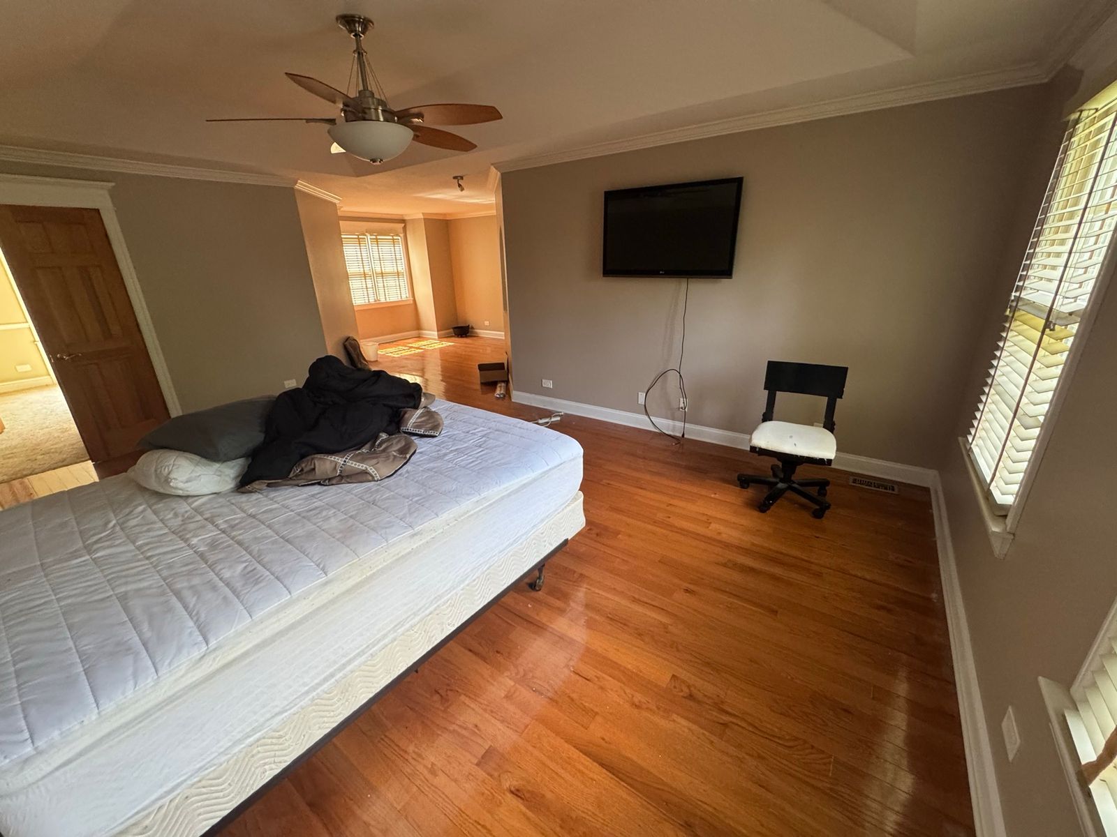 The same bedroom before, seen from the other side, with orange hardwood floors