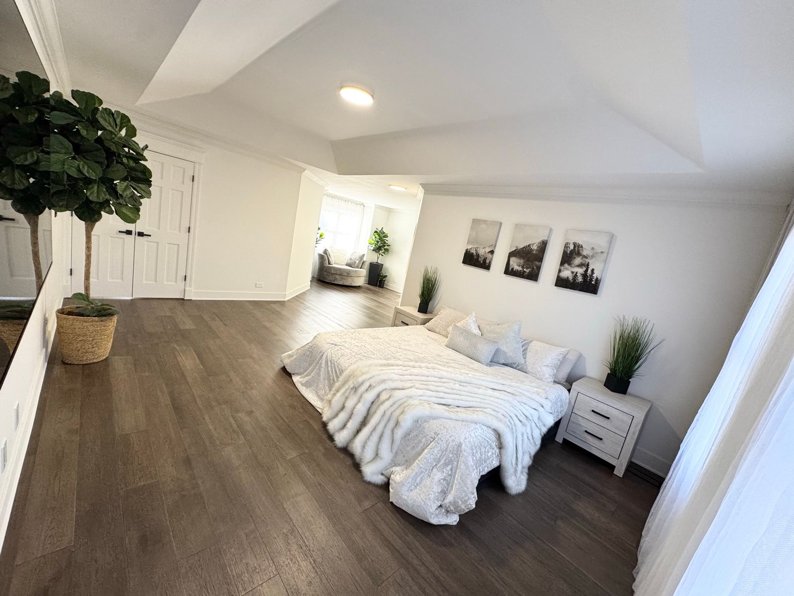 The same bedroom after, with a new plank floor and light walls